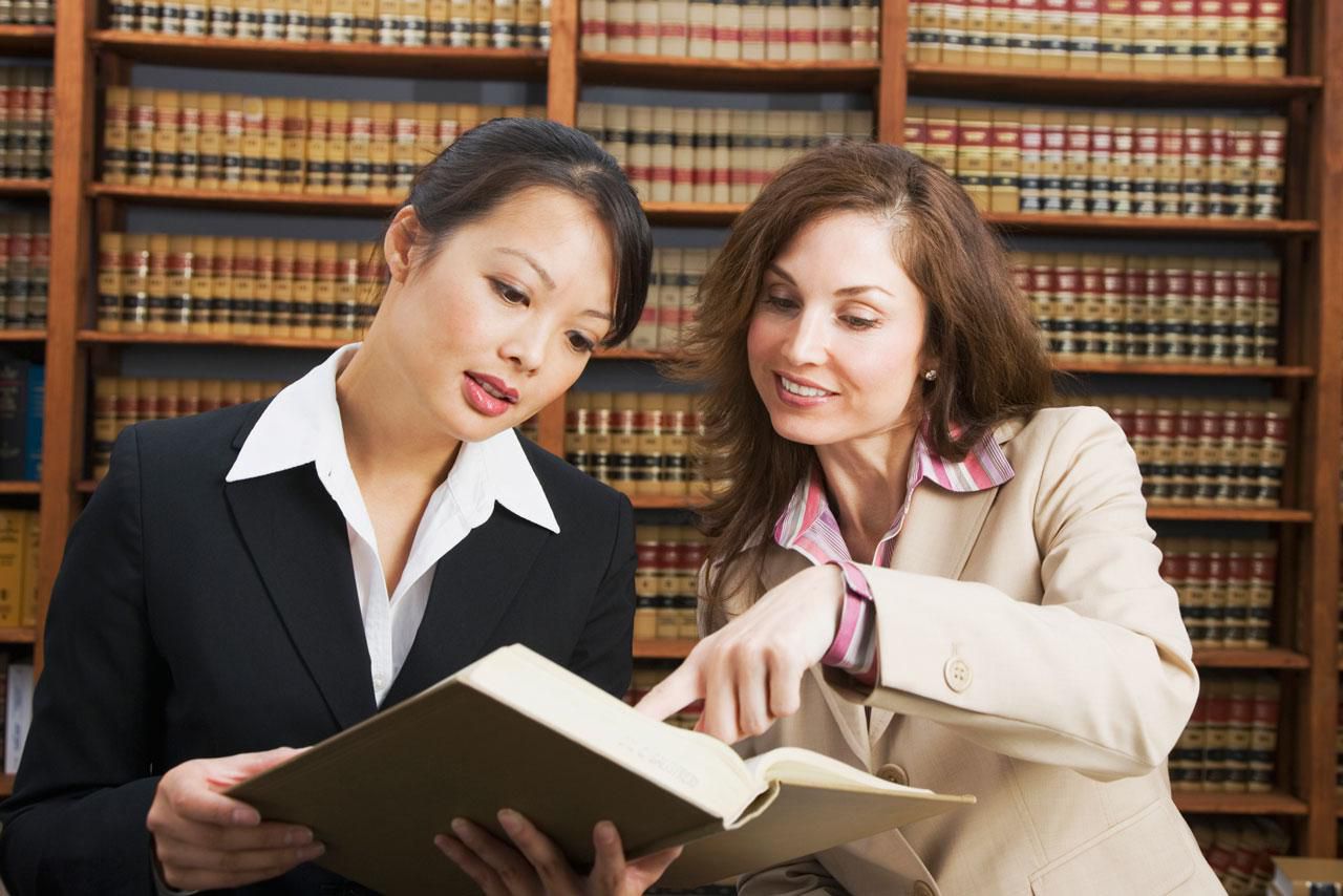 two lawyers reading a law book